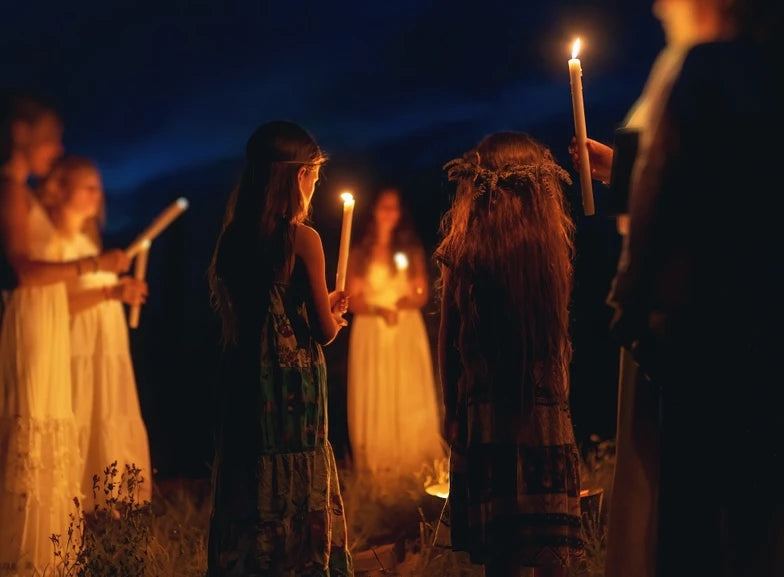 What is traditional witchcraft? Women holding candles outdoors and practicing traditional witchcraft.