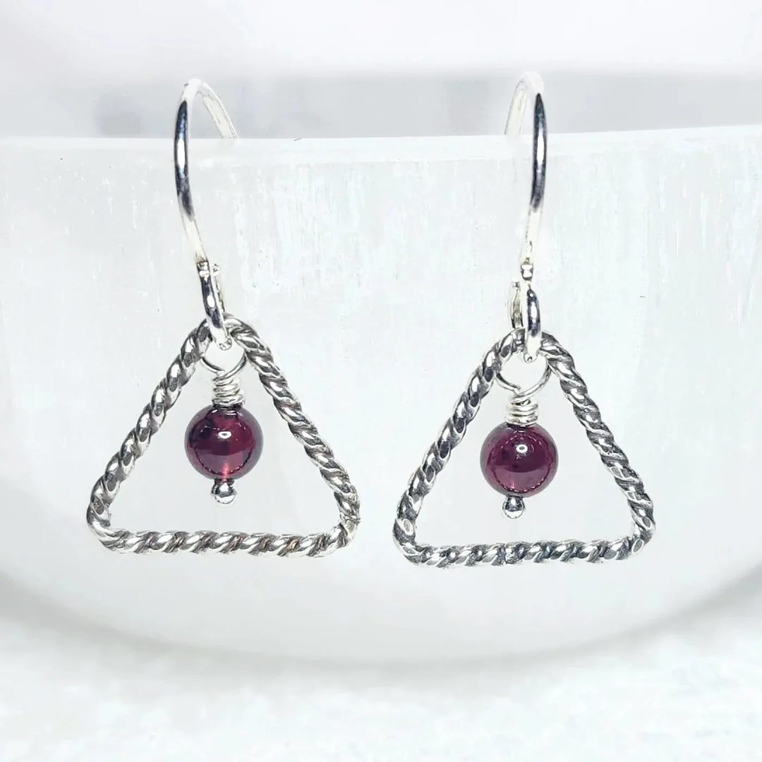 Sterling silver triangle earrings with garnet gemstone bead – handmade minimalist jewelry for passion and vitality.