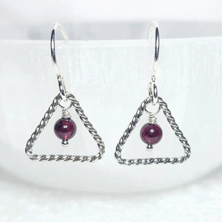 Sterling silver triangle earrings with garnet gemstone bead – handmade minimalist jewelry for passion and vitality.