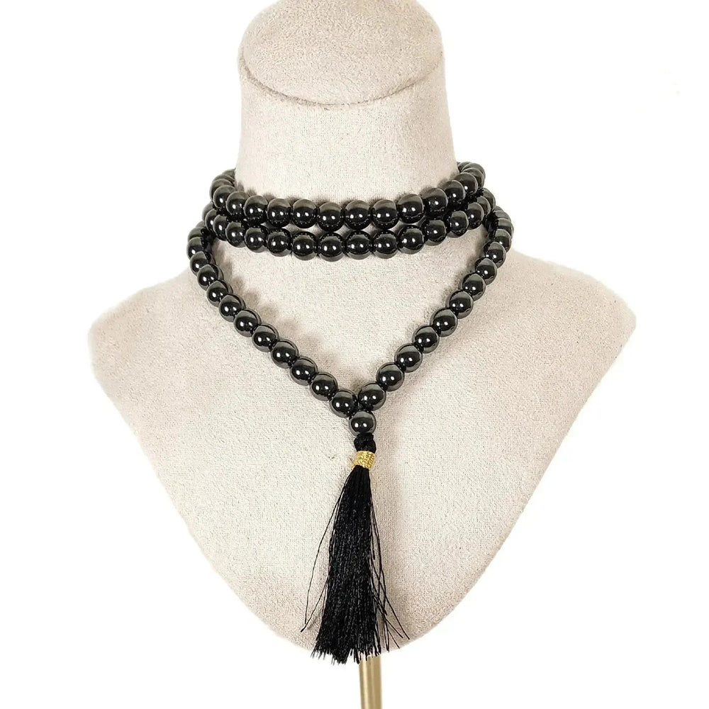 A mannequin wearing Hematite beads from Art of the Root metaphysical supply store.