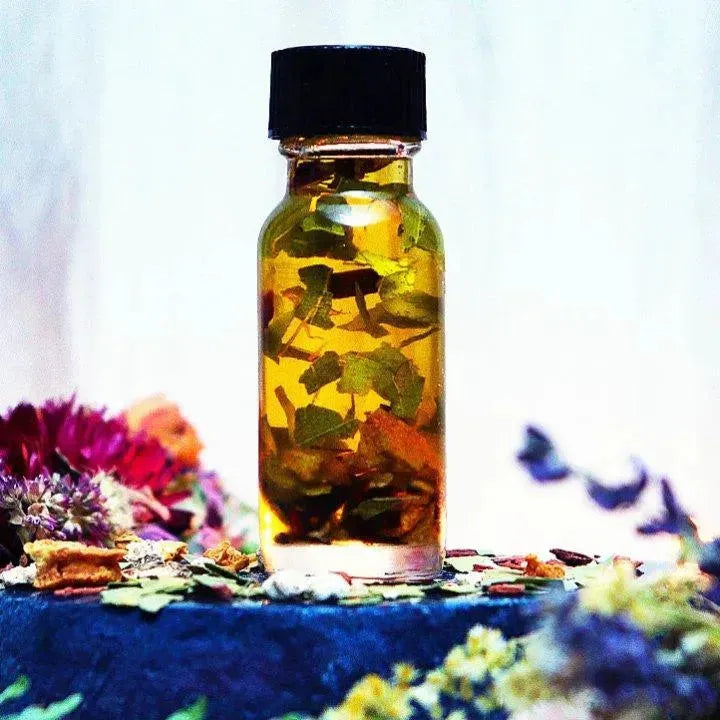 Herbs floating in a bottle of Crown of Success Oil, handmade by Art of the Root.