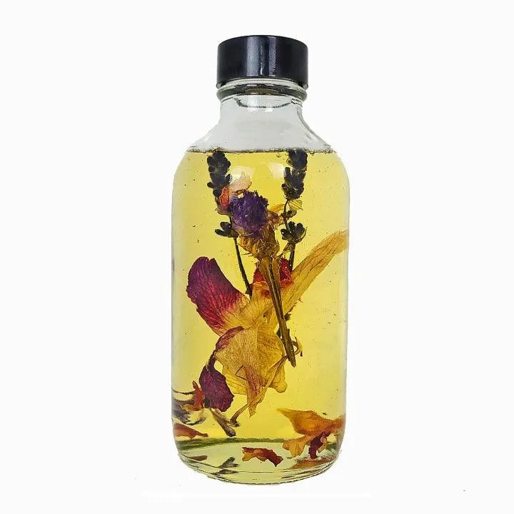 A bottle of Love Intention Ritual Oil. Made with herbs and flowers to supplement love rituals.