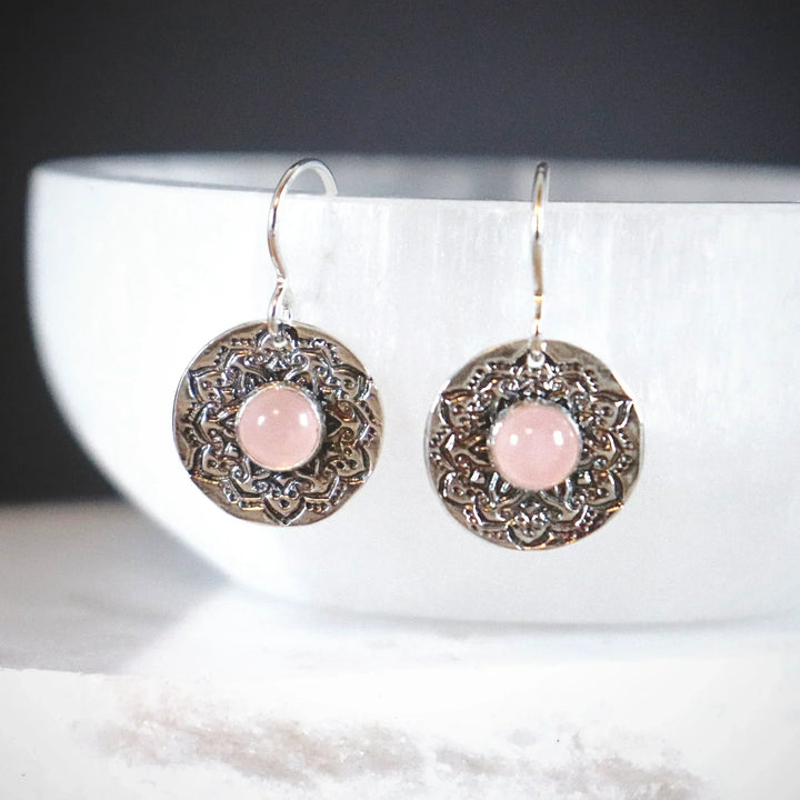 Rose Quartz Mandala Earrings in Fine Silver with Sterling Hooks Hanging on white stone.
