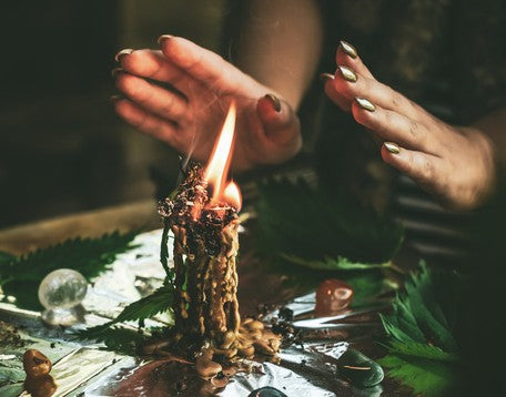 A woman doing a magic ritual after dressing and anointing a candle. Learn how to anoint a candle with oil here.