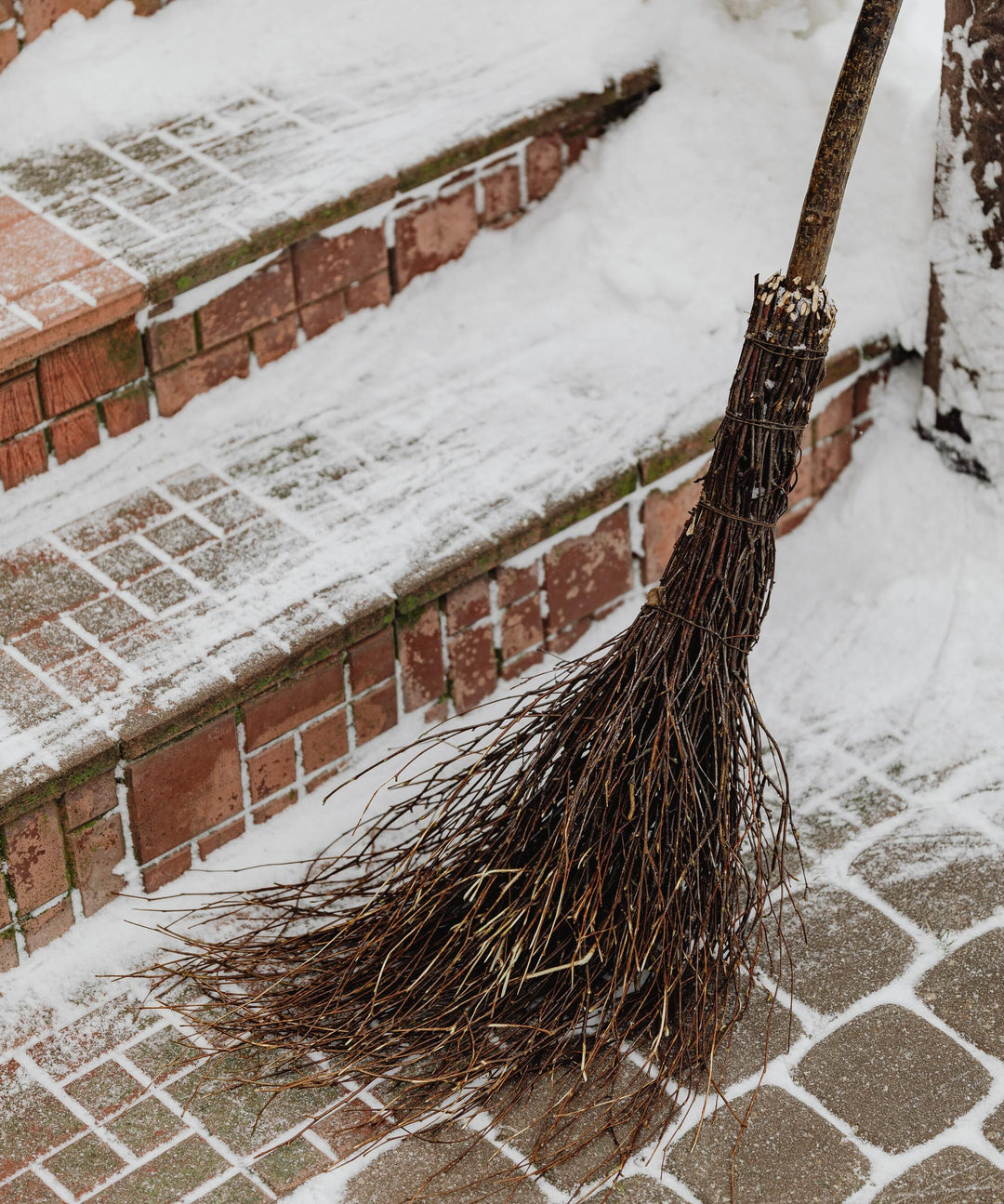 What is a cinnamon broom? A homemade cinnamon broom on a snowy walkway.