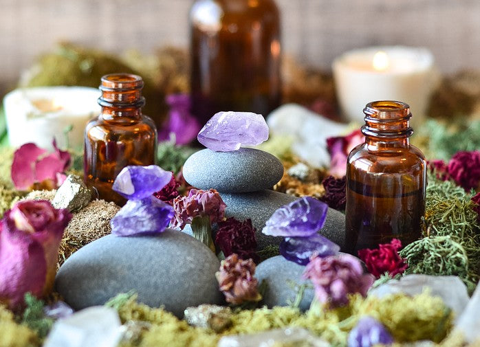 Amethysts and bottles of essential oils. Read about the Top 5 Money-Drawing Essential Oils & How to Use Them here.