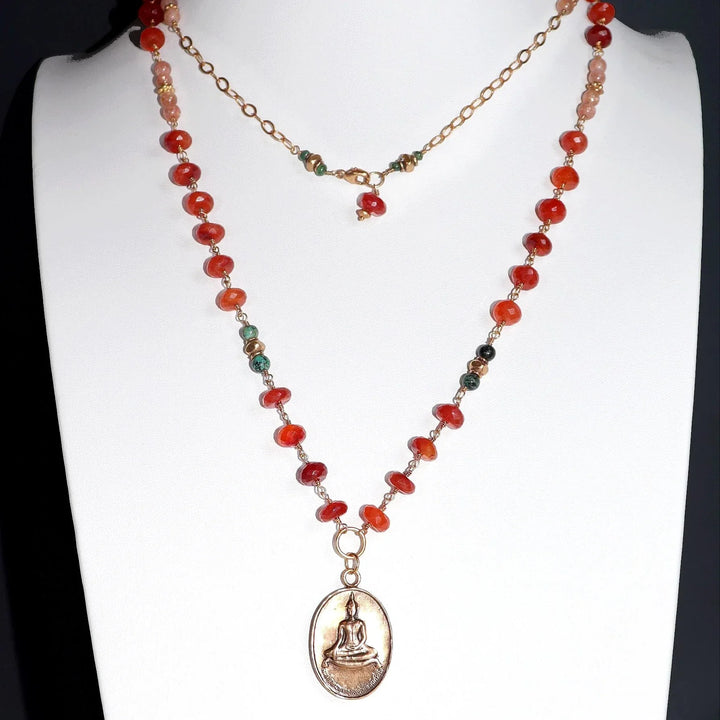 Carnelian and African Turquoise Necklace with Bronze Temple Buddha Charm on White Bust.