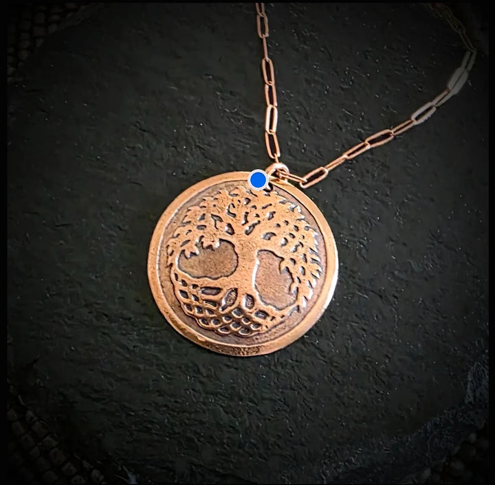 Bronze Copper tone tree of life necklace on a dark background
