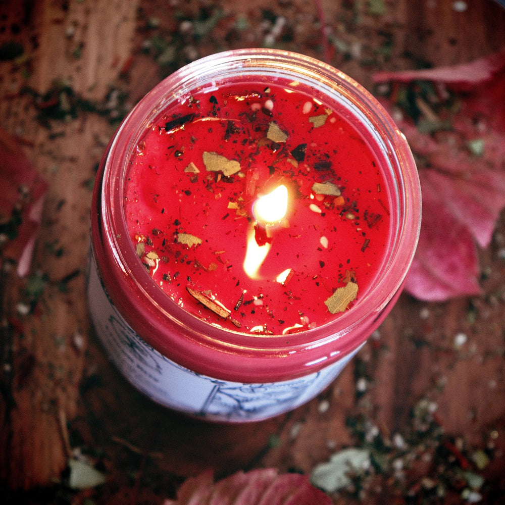 Red Lover Boy Candle burning with natural herbs and botanicals